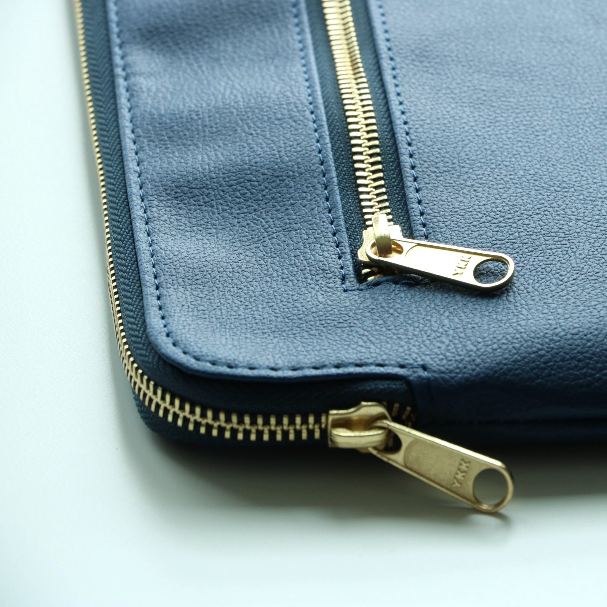 Close-up of high-quality zipper on navy leather ipad case