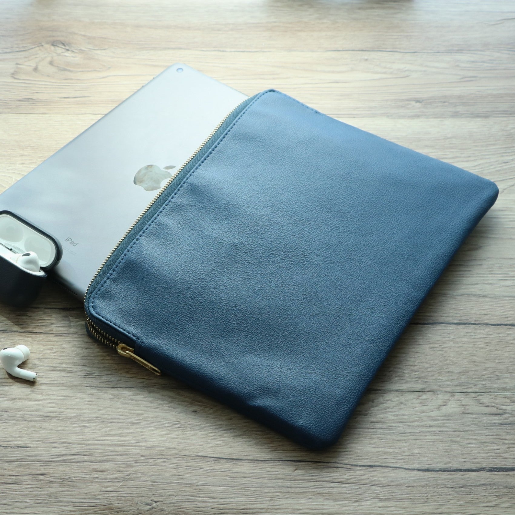 Front view of navy leather tablet sleeve with zipper for men