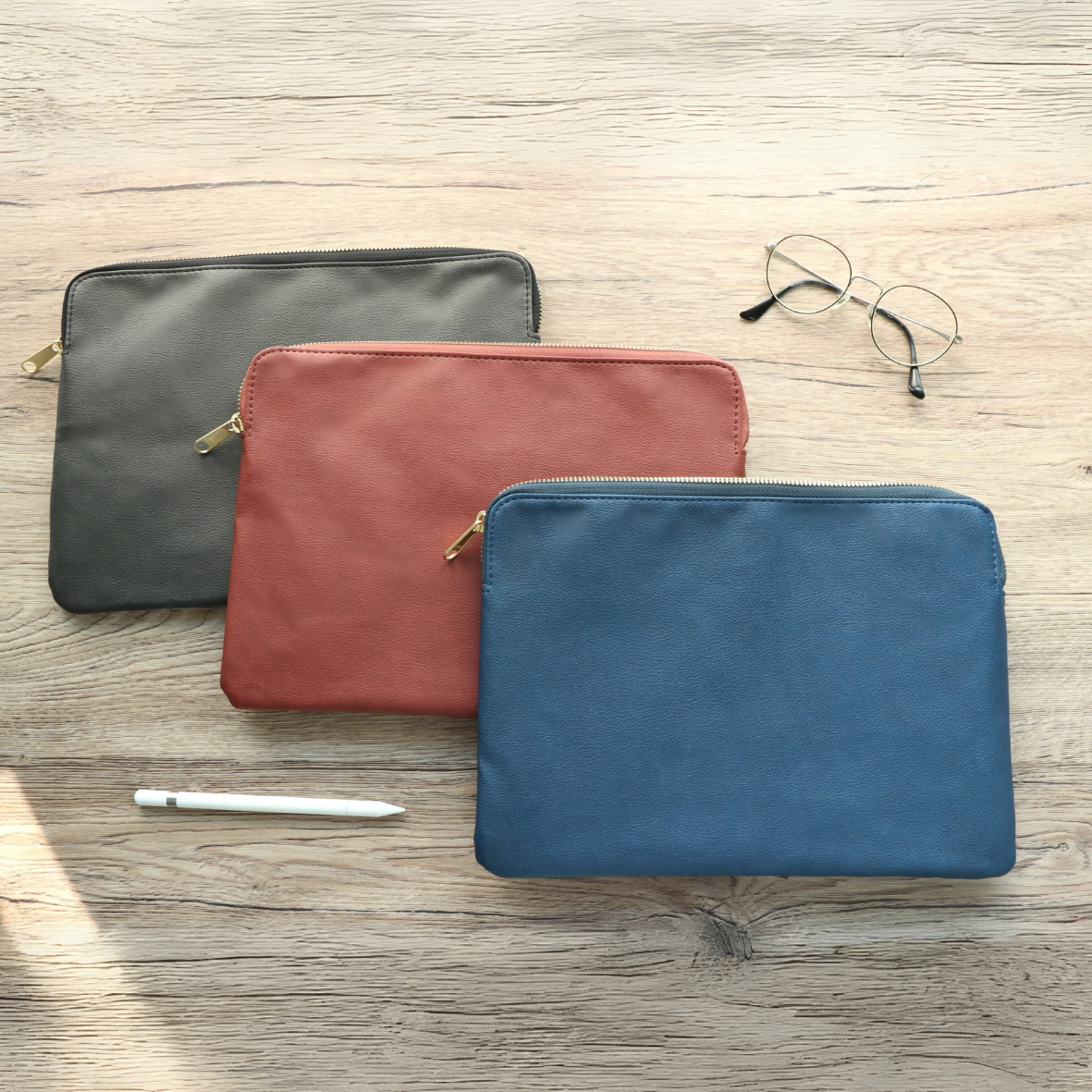 Three leather tablet sleeve in black, brown, and blue for business men on-the-go